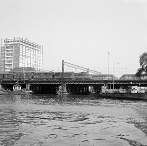 881719 Gezicht op de spoorbrug over de Westertoegang bij het N.S.-station Amsterdam C.S. te Amstrerdam.